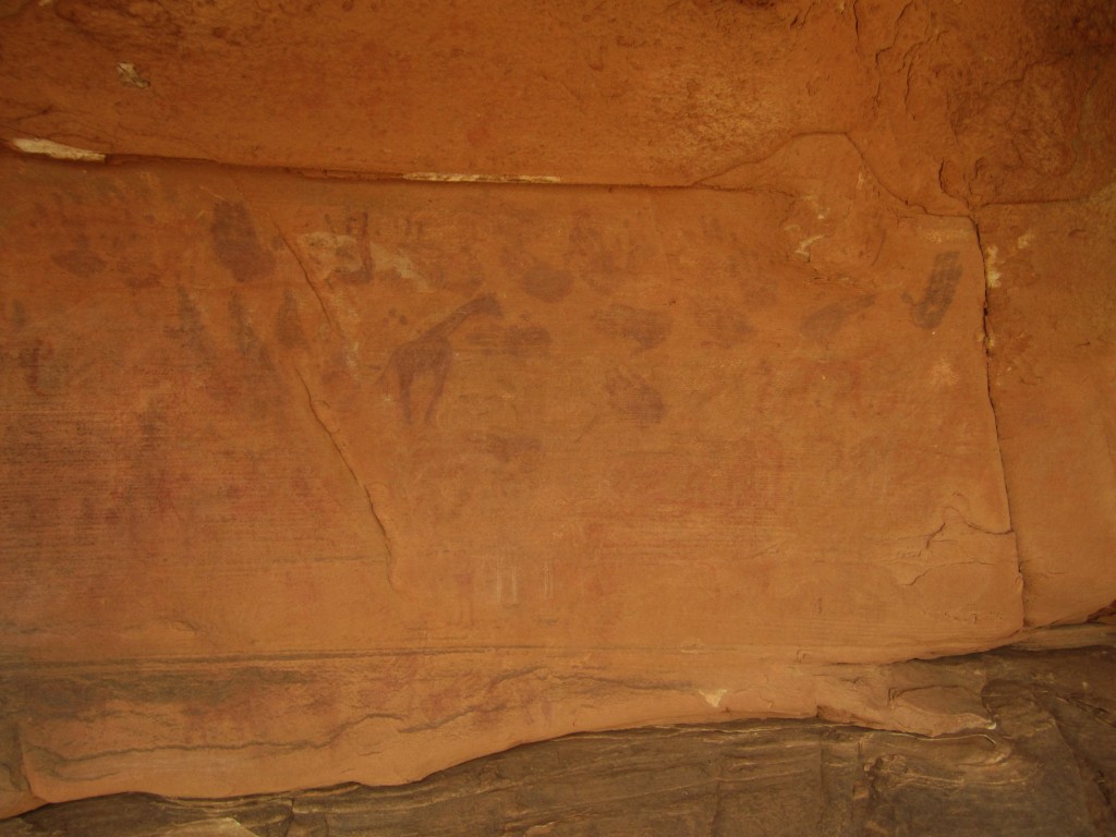Pintura rupestre girafas y manos en el desierto